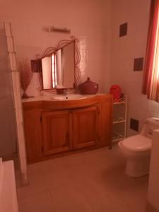a bathroom with a sink and a mirror and a toilet at Villa Savana in Somone