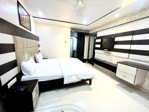 um quarto de hotel com uma cama e uma televisão em HOTEL P PALACE ! VARANASI fully-Air-Conditioned-hotel lift-and-Parking-availability, near Kashi Vishwanath Temple, and Ganga ghat em Varanasi