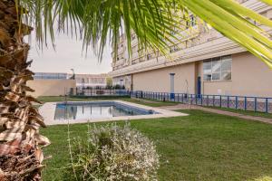 una piscina en un patio junto a un edificio en SevillaHome-Apartamento complejo piscina parking, en Sevilla