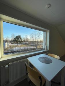 a table and chairs in a room with a large window at Serenity Cottage in Närpiö