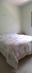 Un dormitorio con una cama con una manta floral. en Casa Inteira e Grande 600MB de Internet. Ótima Loc, en Uberlândia