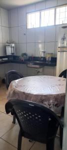 a kitchen with a table and chairs with a tiled wall at Casa Inteira e Grande 600MB de Internet. Ótima Loc in Uberlândia