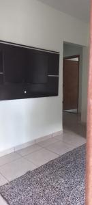 uma parede branca com uma televisão de ecrã plano em Casa Inteira e Grande 600MB de Internet. Ótima Loc em Uberlândia