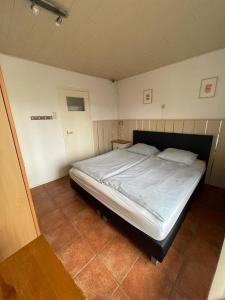 um quarto com uma cama grande num quarto em Vakantiehuisje Martina 17 em Vlissingen