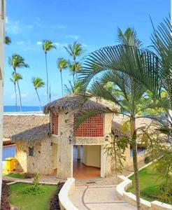 a building with palm trees in front of the ocean at Appartamento Cristal Juan Dolio fronte mare in Juan Pedro