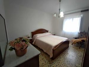 a bedroom with a bed and a table with flowers on it at Casa Innocenti Daniele in Volterra