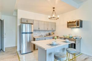 a kitchen with a refrigerator and two bar stools at Downtown Albany Vacation Rental - Chic and Walkable! in Albany