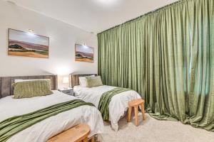 a bedroom with two beds and a window with green curtains at Downtown Albany Vacation Rental - Chic and Walkable! in Albany