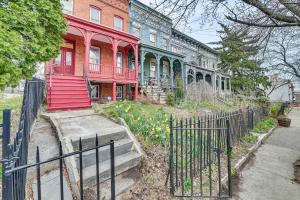 ein rotes Haus mit einem Zaun davor in der Unterkunft Downtown Albany Vacation Rental - Chic and Walkable! in Albany