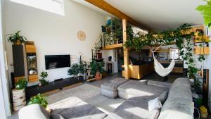 una sala de estar con sofá y muchas plantas en Exklusives Wohnen im Herzen Bayerns - Luxuriöses Haus mit Dachterrasse und Whirlpool, nahe Passau, en Windorf