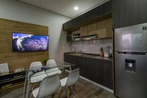 a kitchen with a dining table and a tv on the wall at Sierra Apartments Estudios en Oaxtepec in Oaxtepec