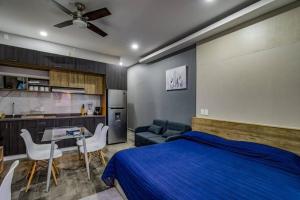 a bedroom with a blue bed and a kitchen at Sierra Apartments Estudios en Oaxtepec in Oaxtepec