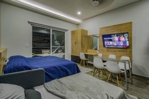 een slaapkamer met een bed en een tafel en stoelen bij Sierra Apartments Estudios en Oaxtepec in Oaxtepec