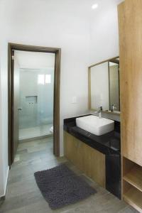 een badkamer met een wastafel, een spiegel en een douche bij Sierra Apartments Estudios en Oaxtepec in Oaxtepec