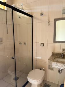 La salle de bains est pourvue de toilettes, d'une douche et d'un lavabo. dans l'établissement Hotel Vila dos Pescadores, à Aparecida