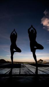 two people are doing yoga on a dock at Casa Ônix View (15km AltoParaíso) - Viagem Inspirada in São João da Aliança