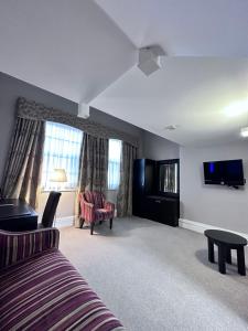 um quarto com uma cama, uma televisão e um sofá em Cathedral Quarter Hotel - Derby em Derby