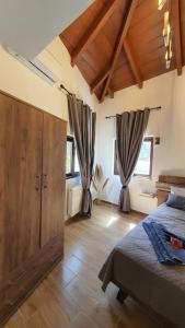 a bedroom with a bed and a large wooden cabinet at Anasa Residence - The Farm house in Varípetron