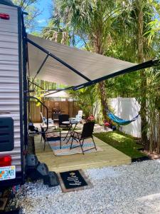 un patio con tenda, tavolo e sedie. di RV Paradise on the Wheels at Clearwater Beaches a Largo