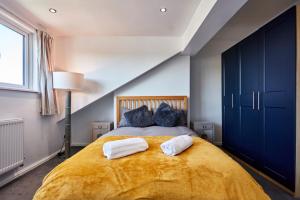 a bedroom with a large bed with two towels on it at Leeds Home Away from Home with parking in Headingley