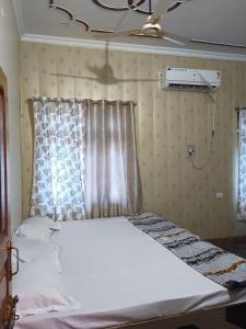 uma cama branca num quarto com uma janela em ARVINDAM VILLA HOMESTAY-THE ESSENCE OF RAMA em Ayodhya