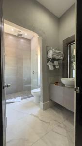 a bathroom with two sinks and a toilet and a shower at Gran Hotel Cantera La plaza in Nuevo Laredo