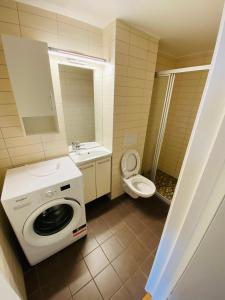 uma casa de banho com uma máquina de lavar roupa e um WC em Torggata Suite Apartments em Oslo