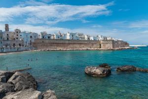 a beach with people in the water and buildings at Palazzo Fiscaiolo in Monopoli