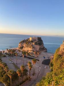 een uitzicht op een kasteel op een heuvel met de oceaan bij Seaway Accommodation " Private Parking " in Tropea