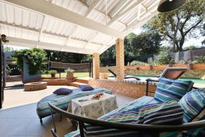eine Terrasse mit 2 Betten, einem Tisch und Stühlen in der Unterkunft FOUR C's Guest Units in Craighall Park in Johannesburg