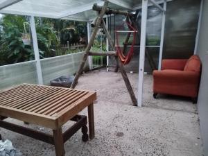 a porch with a chair and a swing at Ficus Cottage - Ramsgate Ramble Rest in Margate