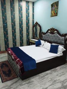 1 dormitorio con 1 cama grande con manta azul en ARVINDAM VILLA HOMESTAY-THE ESSENCE OF RAMA, en Ayodhya