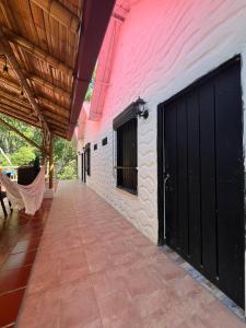 un edificio con una puerta negra y una pared rosa en Cabañas Monteleón Paicol- Huila en La Laja