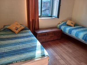 two twin beds in a room with a window at Apartman sa bazenom in Radovići