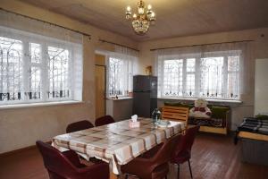 una sala da pranzo con tavolo e alcune finestre di Вила Eco Garden a Gyumri