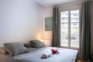 een knuffeldier op een bed in een slaapkamer bij Luxueux et spacieux 100m², Faidherbe, 11th ard in Parijs