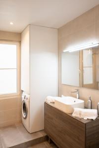 een badkamer met een wastafel en een wasmachine bij Luxueux et spacieux 100m², Faidherbe, 11th ard in Parijs