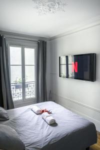 een slaapkamer met een bed, een tv en een raam bij Luxueux et spacieux 100m², Faidherbe, 11th ard in Parijs