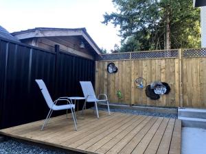two chairs and a table on a wooden deck at Gorgeous 2 Bedrooms Suite Private entrane with patio-Free Parking in Maple Ridge