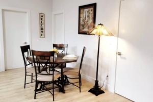 a dining room with a table and chairs and a lamp at Gorgeous 2 Bedrooms Suite Private entrane with patio-Free Parking in Maple Ridge