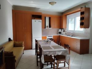 eine Küche mit Tisch und Stühlen sowie einem weißen Kühlschrank in der Unterkunft Caspy in Kerames