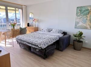 a bedroom with a bed and a chair and a table at 5 minutes metro free parking 2 bedrooms 4-6P Near Paris in Malakoff