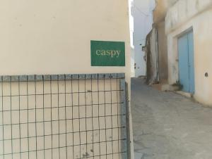 ein Schild an der Seite eines Gebäudes mit einem Zaun in der Unterkunft Caspy in Kerames