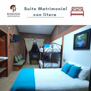 a bedroom with a bed with blue pillows at Suite Hotel Romanos in Playas