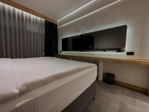 ein Schlafzimmer mit einem Bett und einem großen TV in der Unterkunft S-Cape Hotel Fethiye in Fethiye