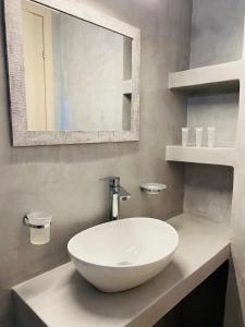 a bathroom with a white sink and a mirror at Alkyon Hotel in Parikia