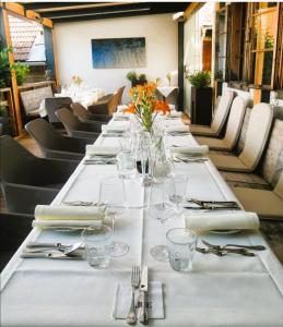 a long table with white plates and glasses on it at Bett in der Wies´n, Restaurant Triad in Bad Schönau