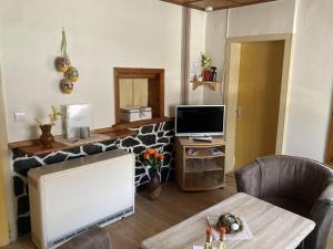 a living room with a tv and a table and a televisionicter at Secluded Holiday Home in Lichtenau with Private Garden in Langenbach