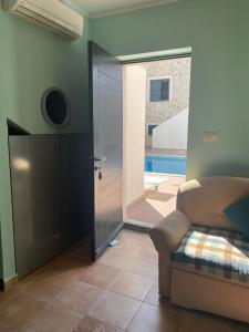 a living room with a couch and a door to a pool at Apartman green home (pool) in Radovići