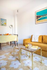 a living room with a couch and a table at Le Petit Jaune : Centre ville T2 avec balcon in Marseille